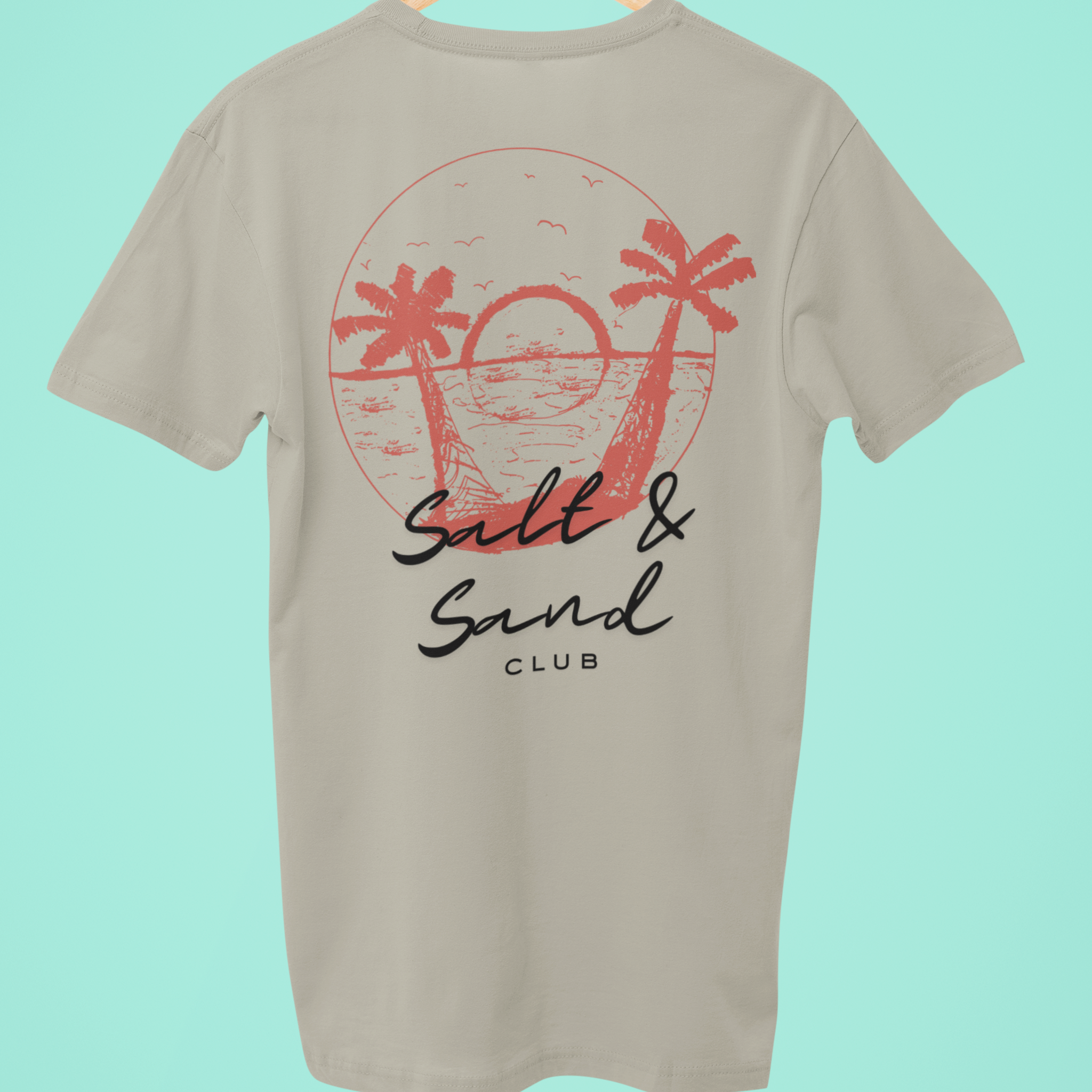 This sand custom tee shirt features a unique coral 'Salt & Sand Club' design on the back, perfect for beachwear enthusiasts looking for stylish and personalized summer fashion.