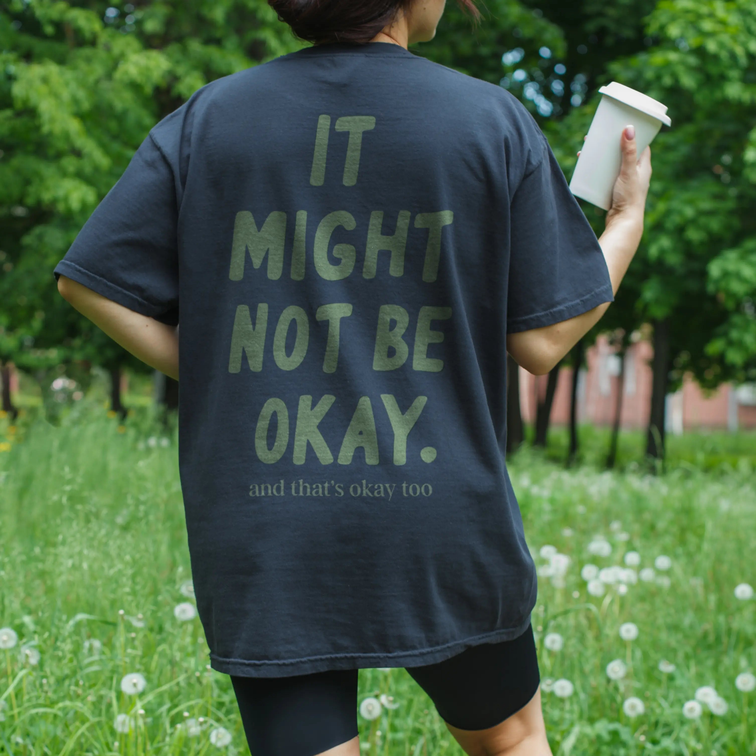 Lifestyle shot of "It Might Not Be Okay" comfort tee - perfect for surviving life and awkward conversations