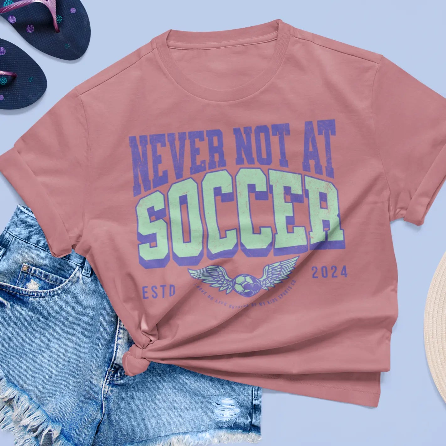 Lifestyle shot of knotted "Never Not At Soccer" tee with summer outfit - soccer parent shirt for field-dwelling moms