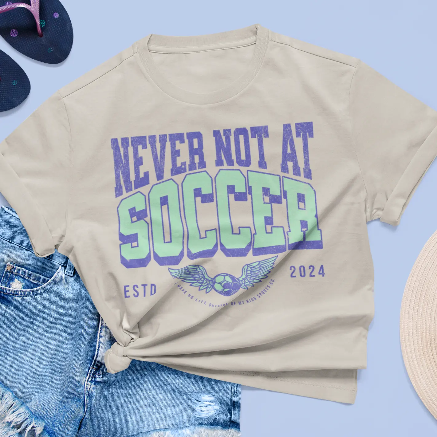 Flat lay "Never Not At Soccer" tee with flip flops - soccer mom tournament shirt for parents married to the field