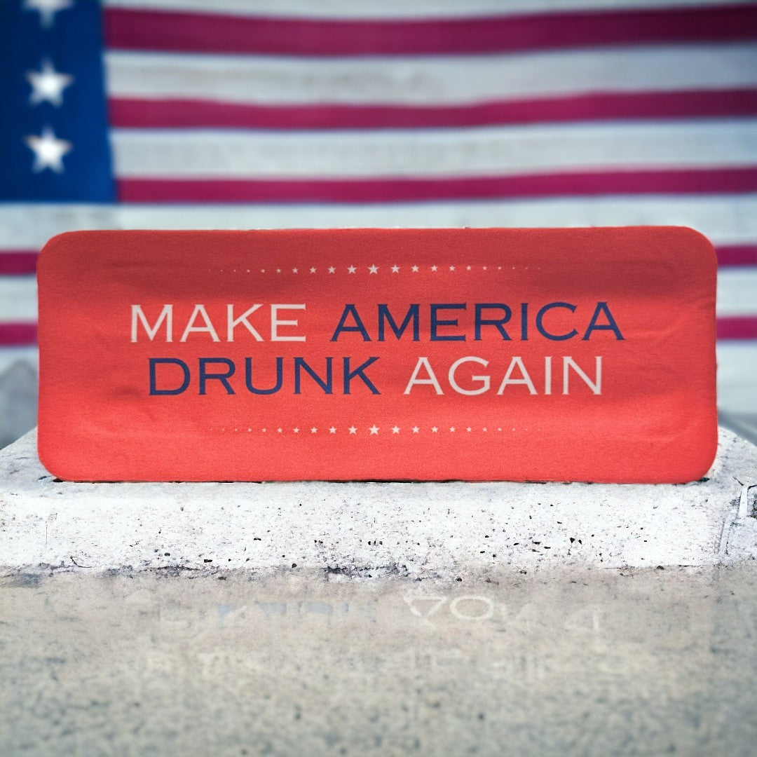 Customizable red koozie with 'Make America Drunk Again' printed in front of an American flag, perfect for personalized gifts and patriotic celebrations