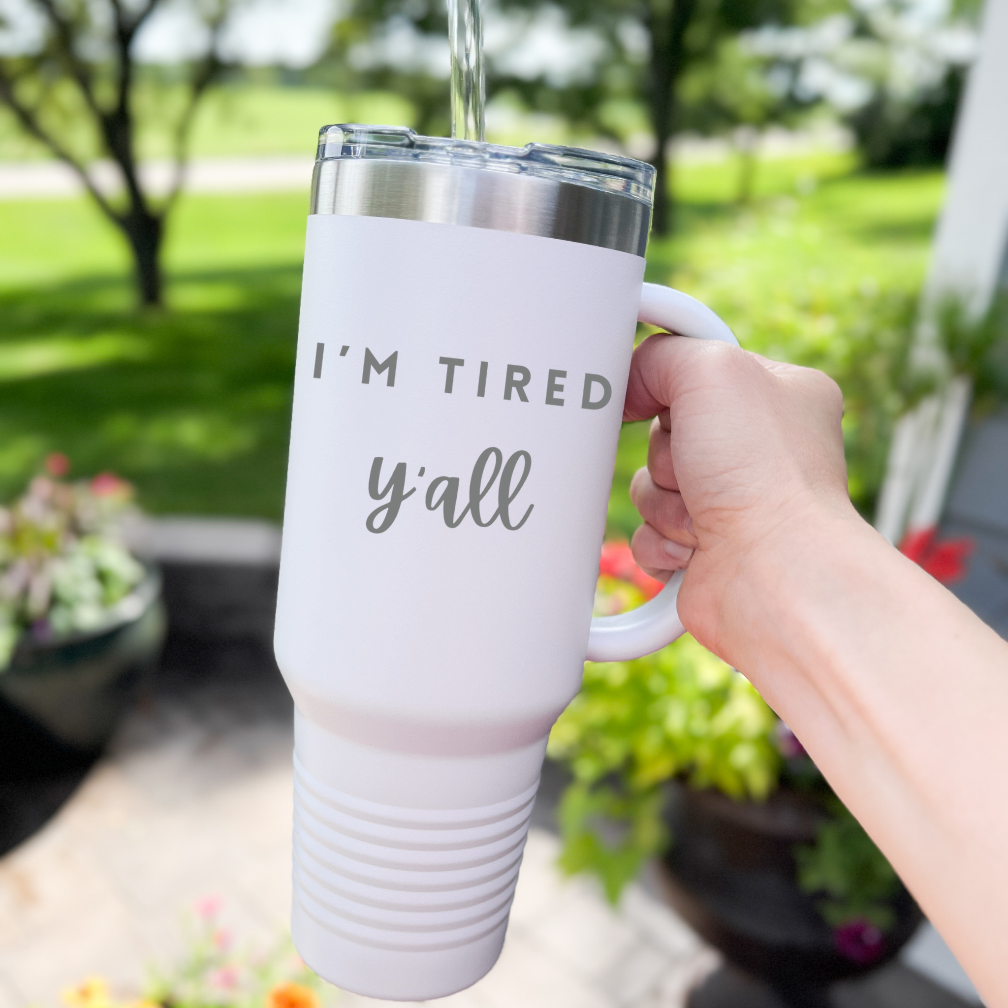 40 oz stainless steel tumbler with the phrase 'I’m Tired Y’all,' featuring a handle and spill-resistant lid, perfect for keeping drinks hot or cold.
