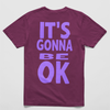 Vineyard Oversized black tee with "It’s Gonna Be OK" printed in bold purple text on the back, styled for casual and confident comfort.