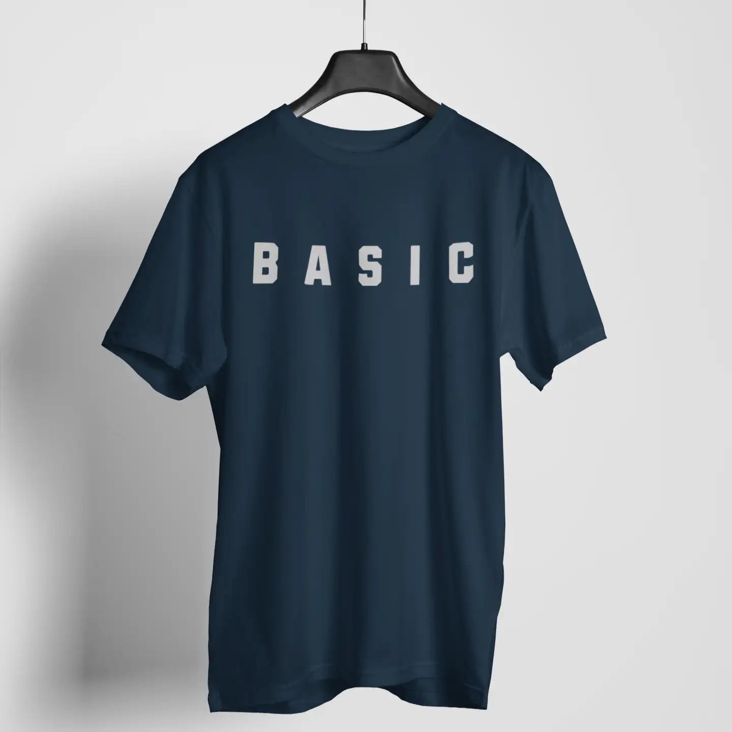 Studio hanger mockup of "BASIC" organic cotton tee - minimalist shirt with maximum sarcasm and soft comfort