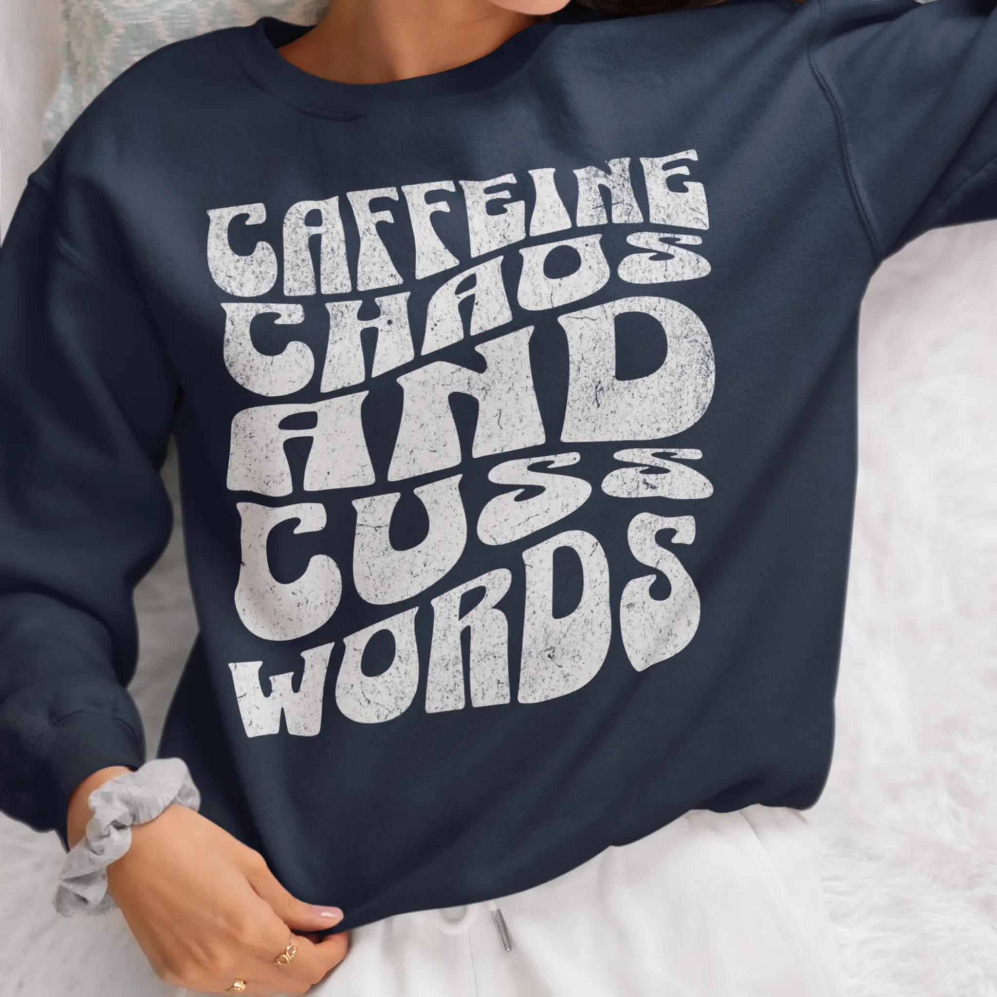 Lifestyle shot of "Caffeine Chaos And Cuss Words" crewneck sweatshirt - funny mom life apparel for parents surviving chaos with coffee and cuss words