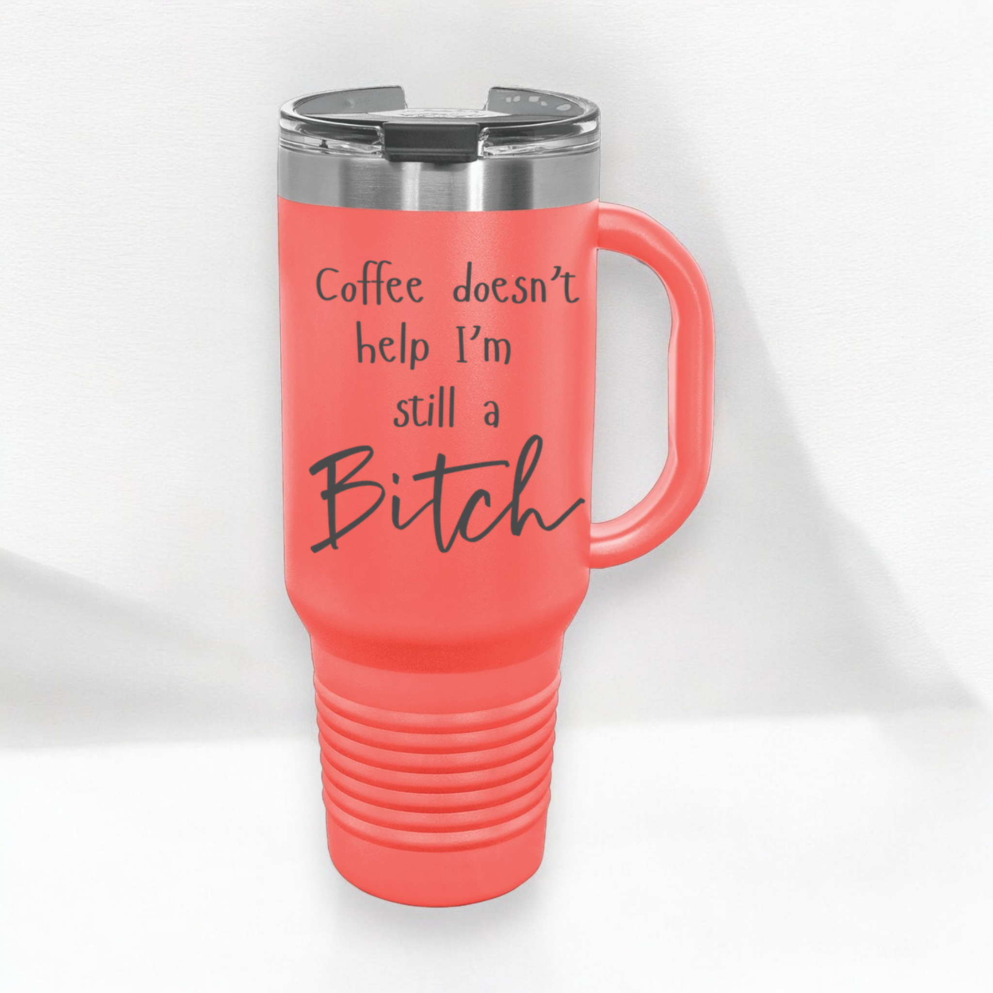 Coral 40 oz stainless steel tumbler with a lid, featuring the humorous engraved quote, "Coffee doesn’t help, I’m still a bitch," and a built-in handle.