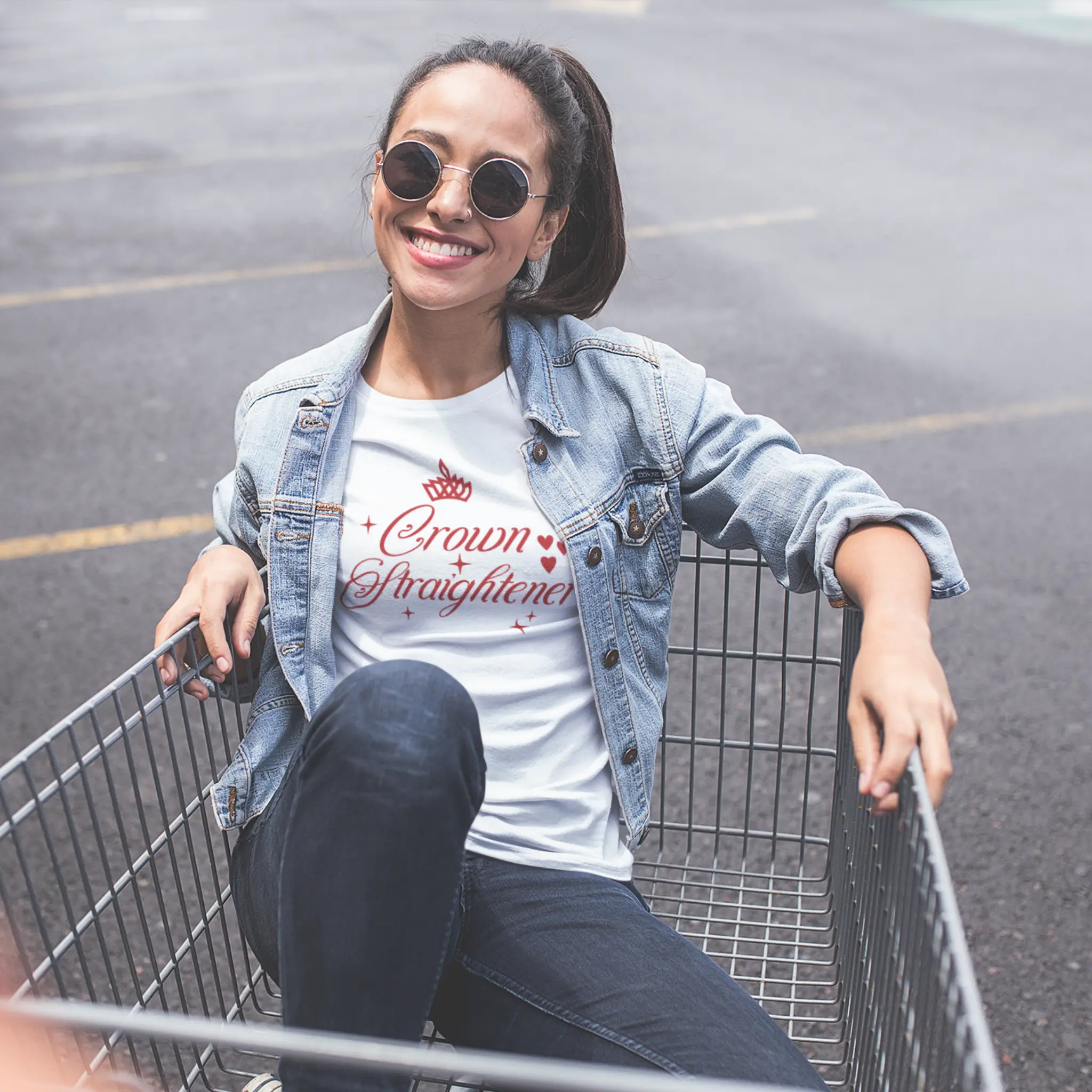 Lifestyle shot of "Crown Straightener" t-shirt - two girls having fun with shopping cart celebrating friendship and carefree moments
