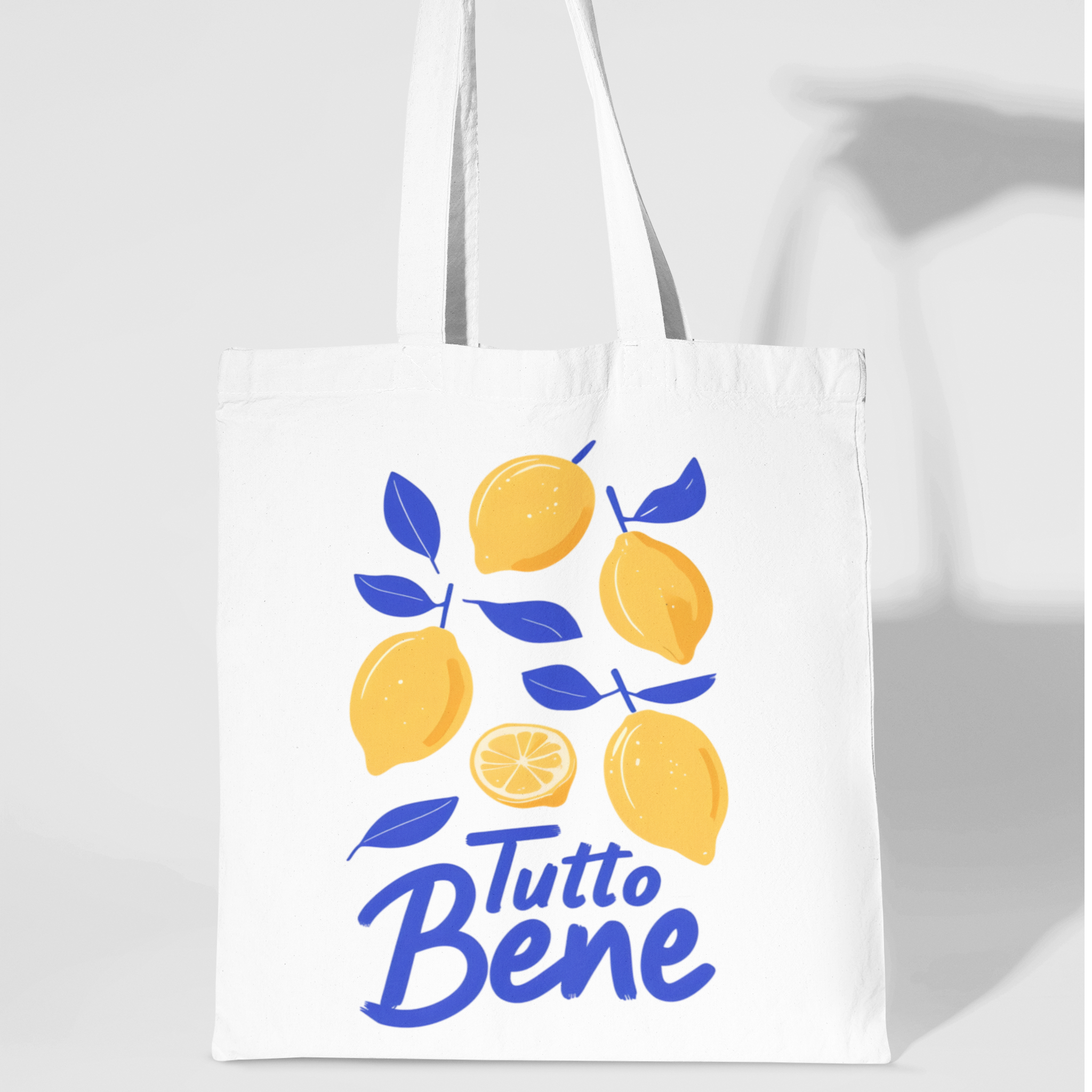 White cotton tote bag with yellow lemons and blue “Tutto Bene” text holding hand italian sayings