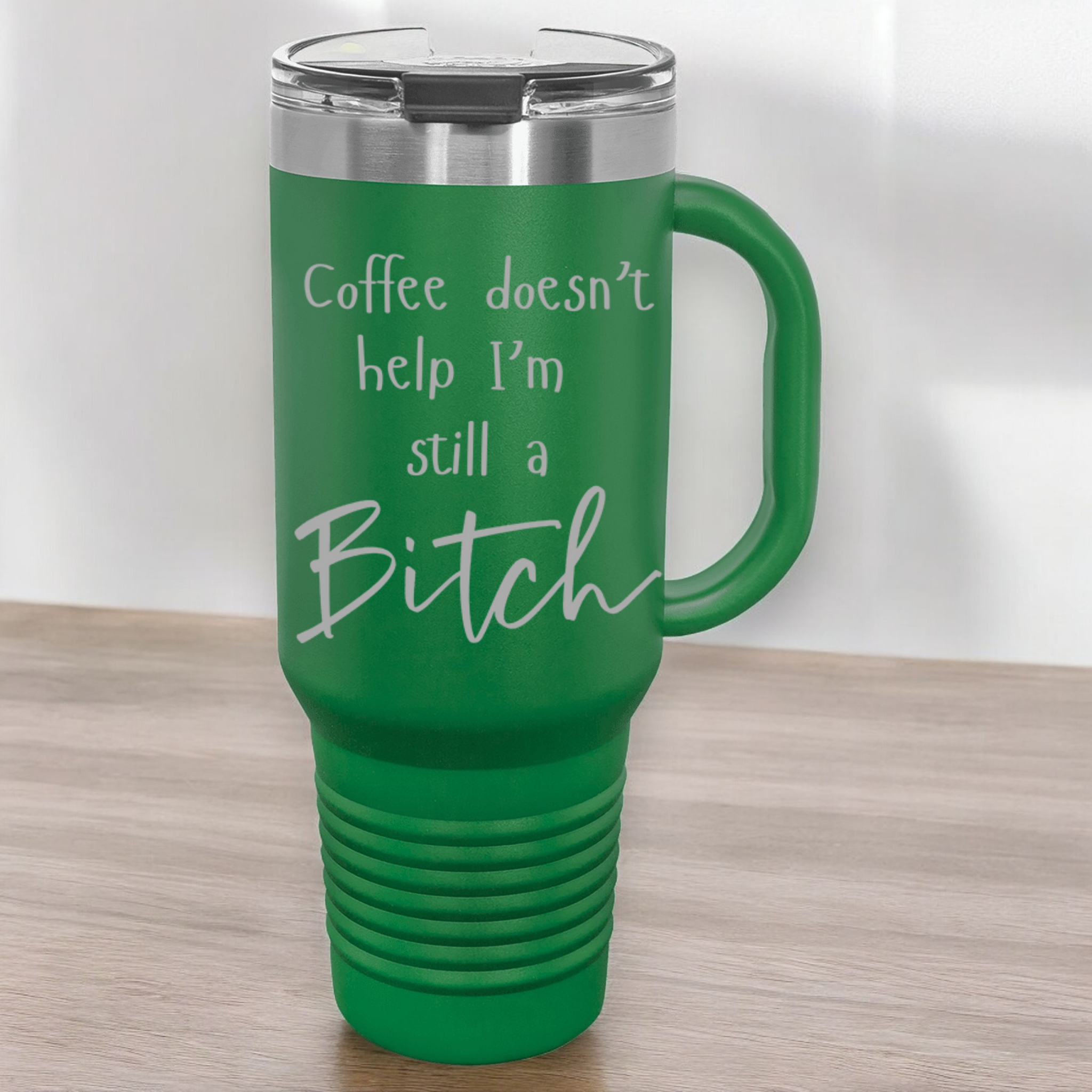 Green 40 oz stainless steel tumbler with a lid, featuring the humorous engraved quote, "Coffee doesn’t help, I’m still a bitch," and a built-in handle.