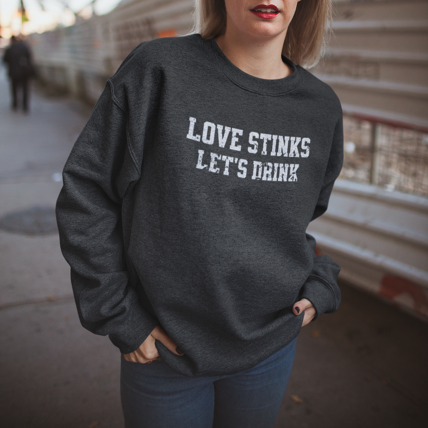 Dark Gray 'Love Stinks, Let's Drink' crewneck sweatshirt with bold white distressed lettering, perfect for cozy anti-Valentine's style.