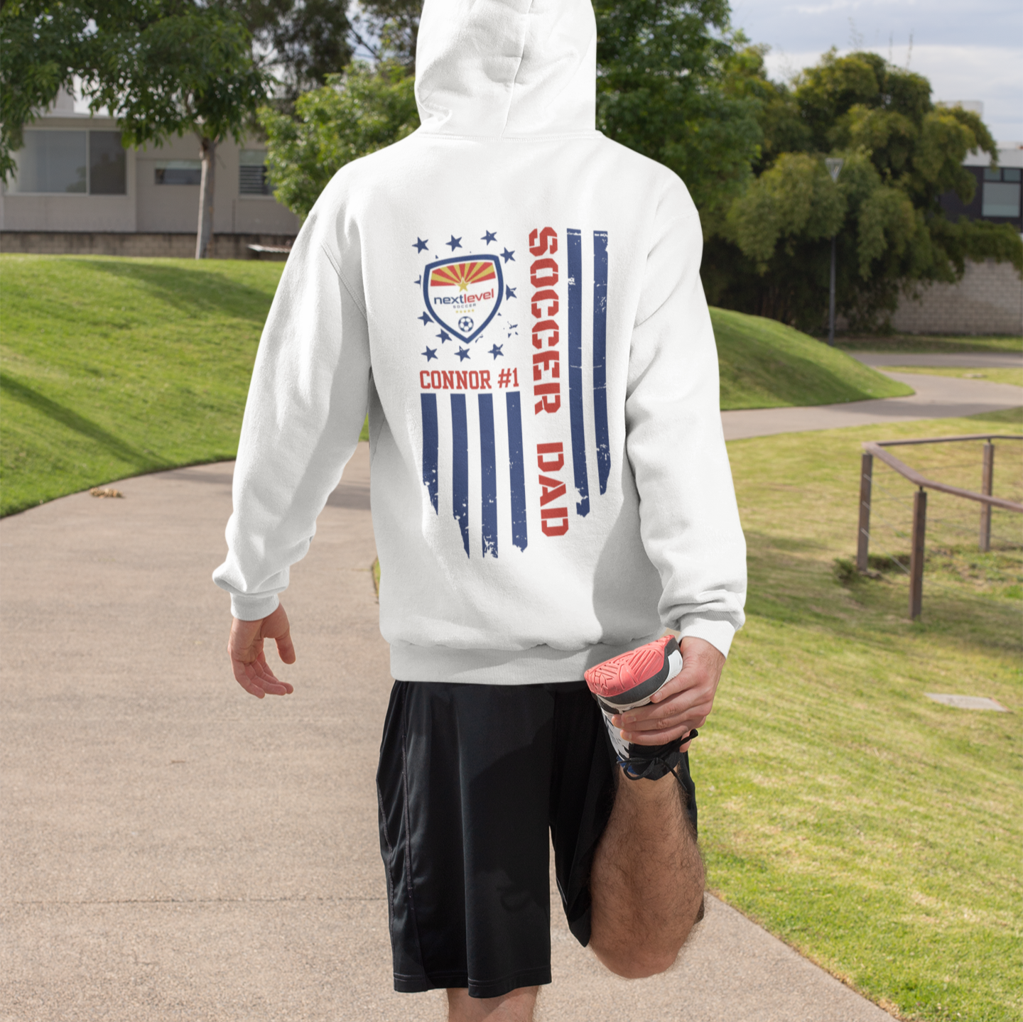 Man ready to run with customizable soccer team hoodies featuring team logo, player name, and number with color-matched flag and text, perfect for soccer fans and players