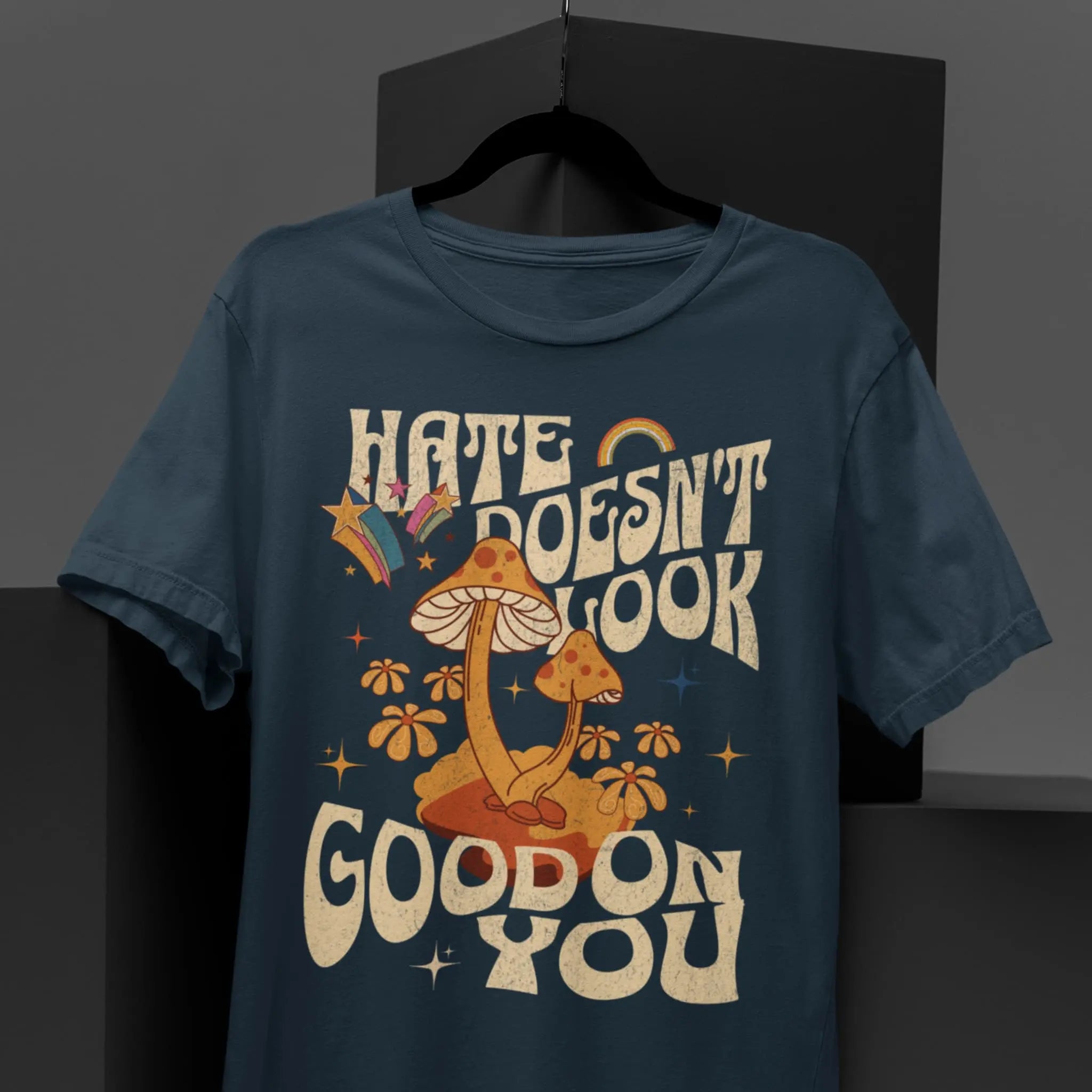 Unisex graphic tee with “Hate Doesn’t Look Good On You” quote and whimsical mushroom artwork, kindness shirt