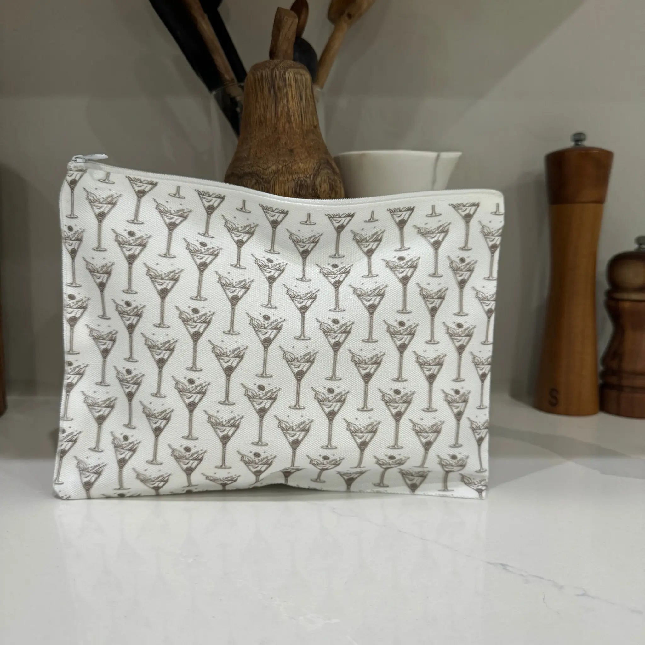 Martini glass makeup bag canvas zipper pouch on kitchen counter lifestyle shot - cosmetic bag perfect for cocktail lovers and bar accessories

