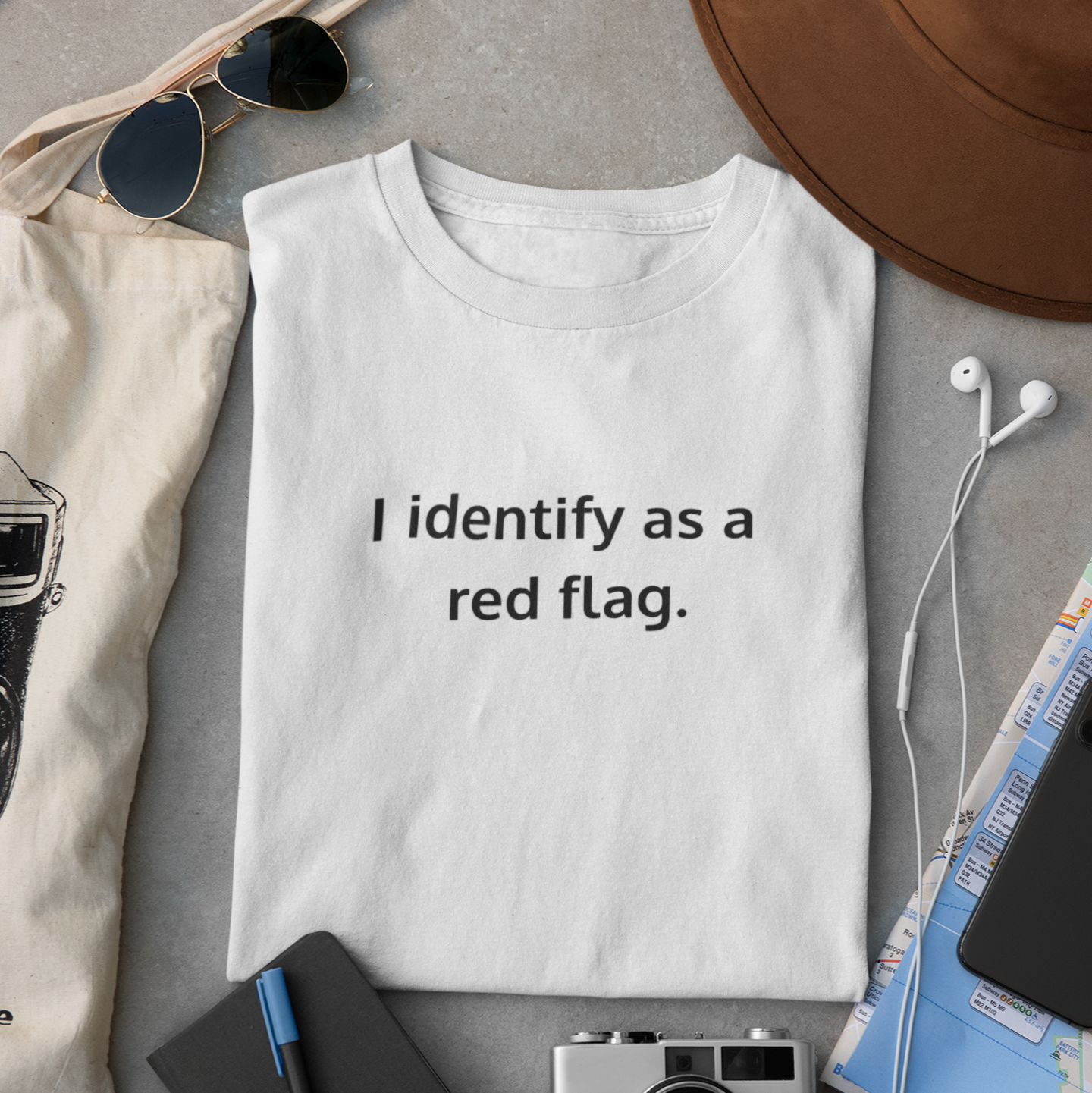 Folded white Comfort Colors t-shirt with “I identify as a red flag” design