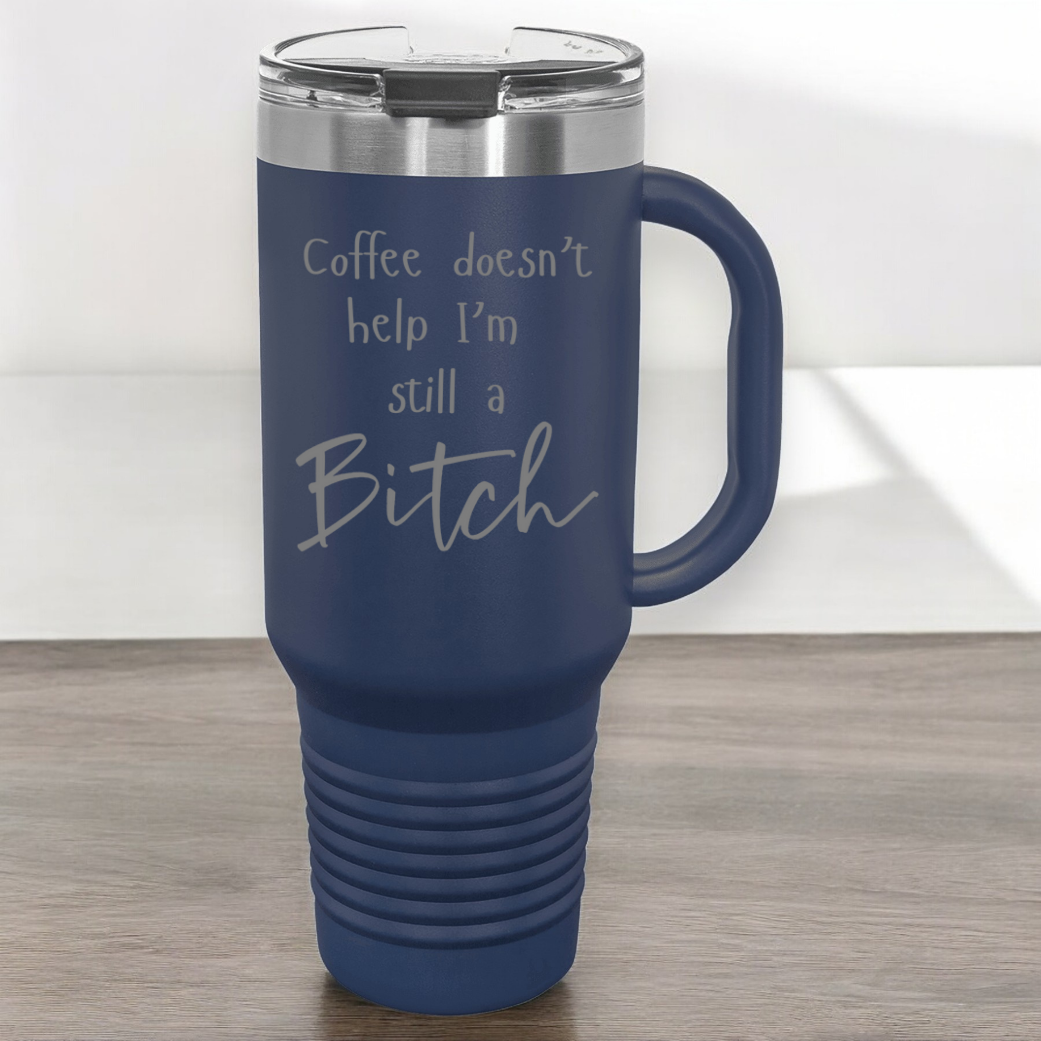 Navy 40 oz stainless steel tumbler with a lid, featuring the humorous engraved quote, "Coffee doesn’t help, I’m still a bitch," and a built-in handle.
