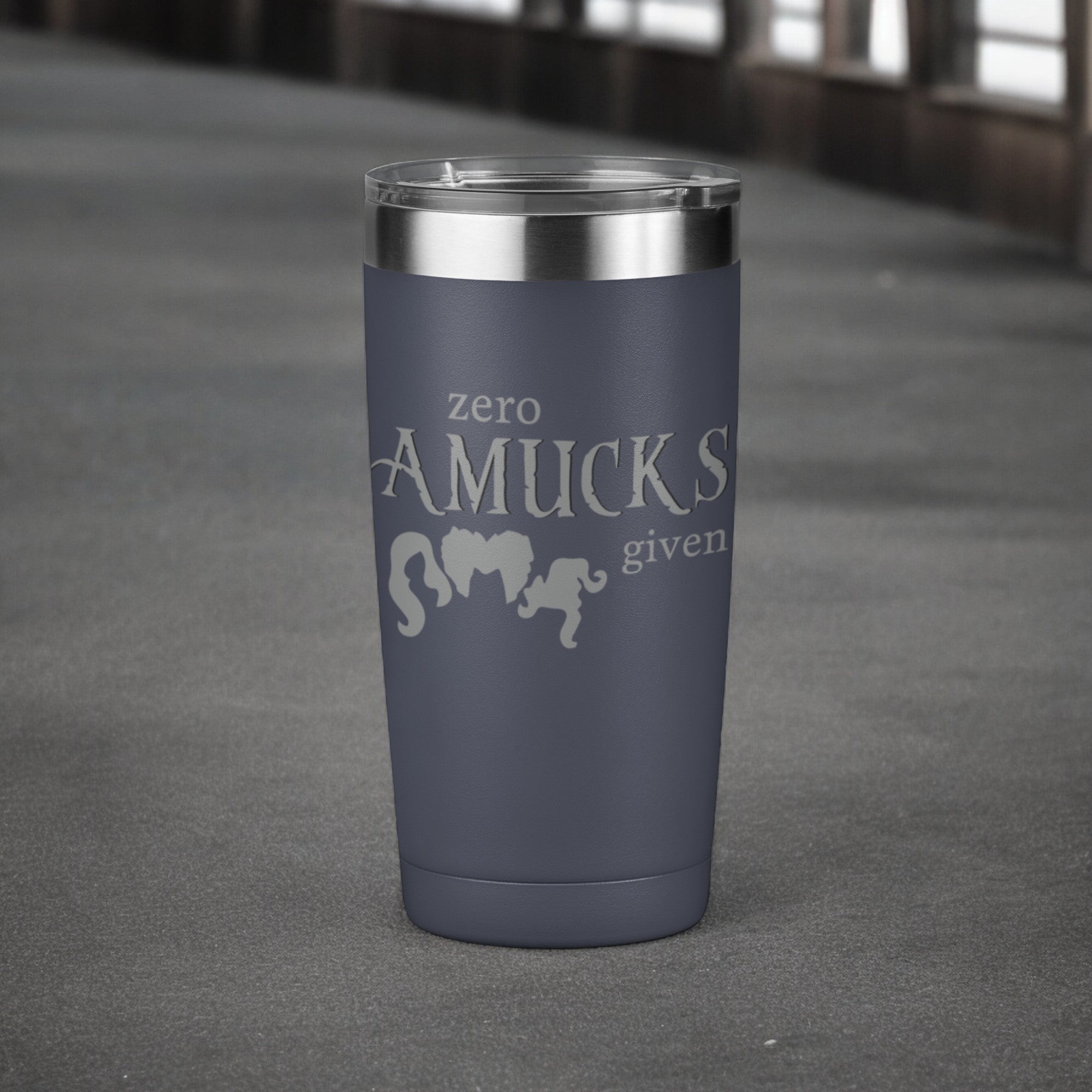 Navy tumbler with silver text that reads "Zero Amucks Given," featuring silhouettes of three witches' hairstyles, perfect for Halloween-themed drinkware.