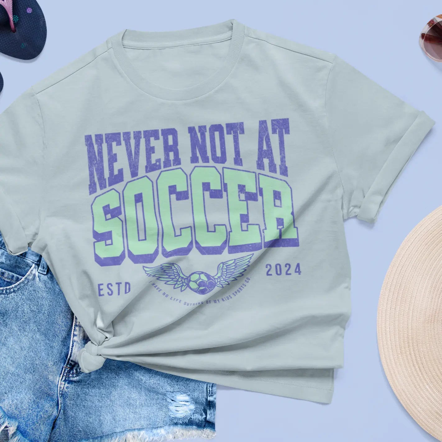 "Never Not At Soccer" tee lifestyle flat lay with denim shorts - soccer mom shirt for parents who live at the field