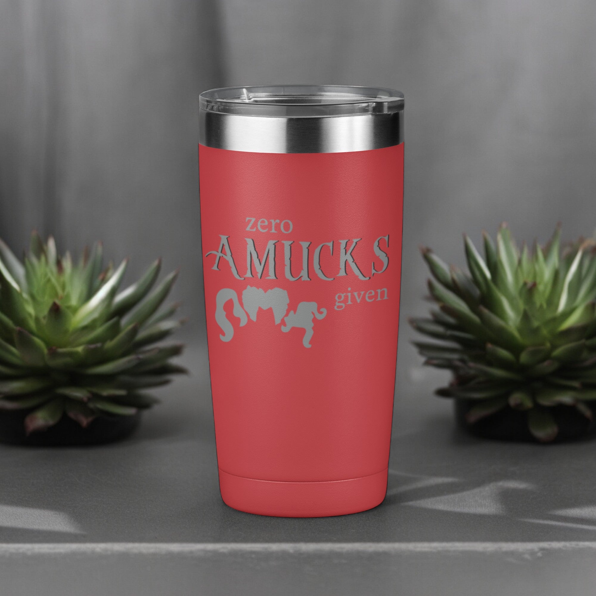 Red tumbler with silver text that reads "Zero Amucks Given," featuring silhouettes of three witches' hairstyles, perfect for Halloween-themed drinkware.