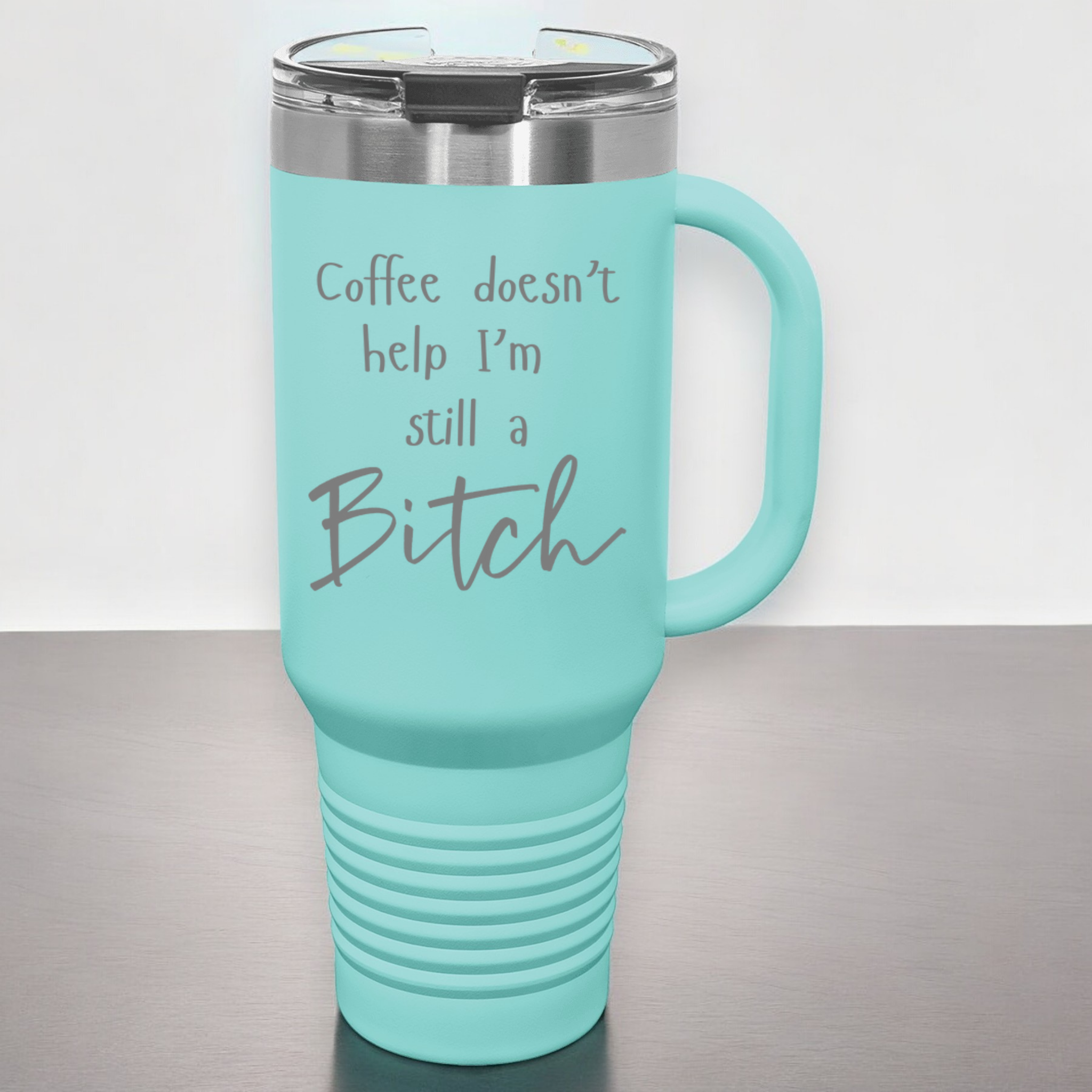 Teal 40 oz stainless steel tumbler with a lid, featuring the humorous engraved quote, "Coffee doesn’t help, I’m still a bitch," and a built-in handle.