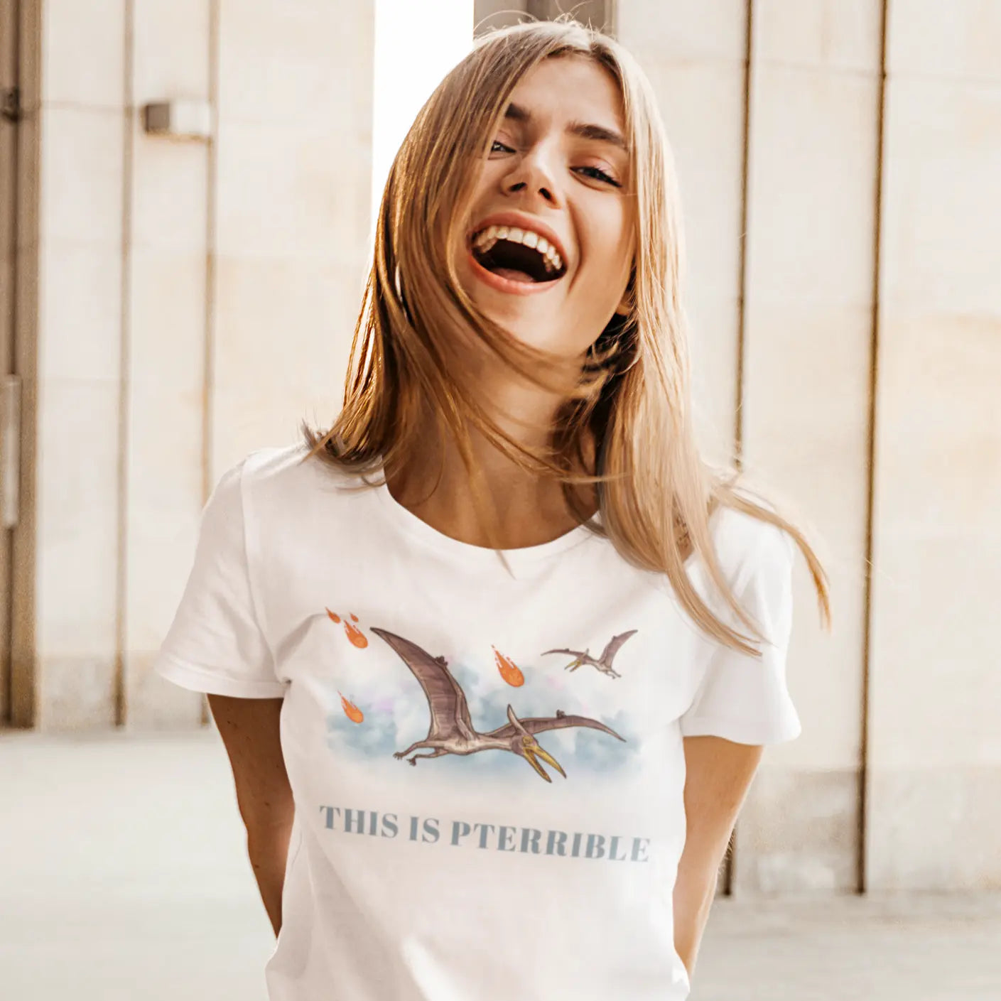 Woman laughing while wearing “This Is Pterrible” dinosaur pun t-shirt featuring pterodactyl artwork