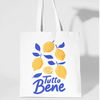 White tote bag with lemon design and 'Tutto Bene' text on a light gray background