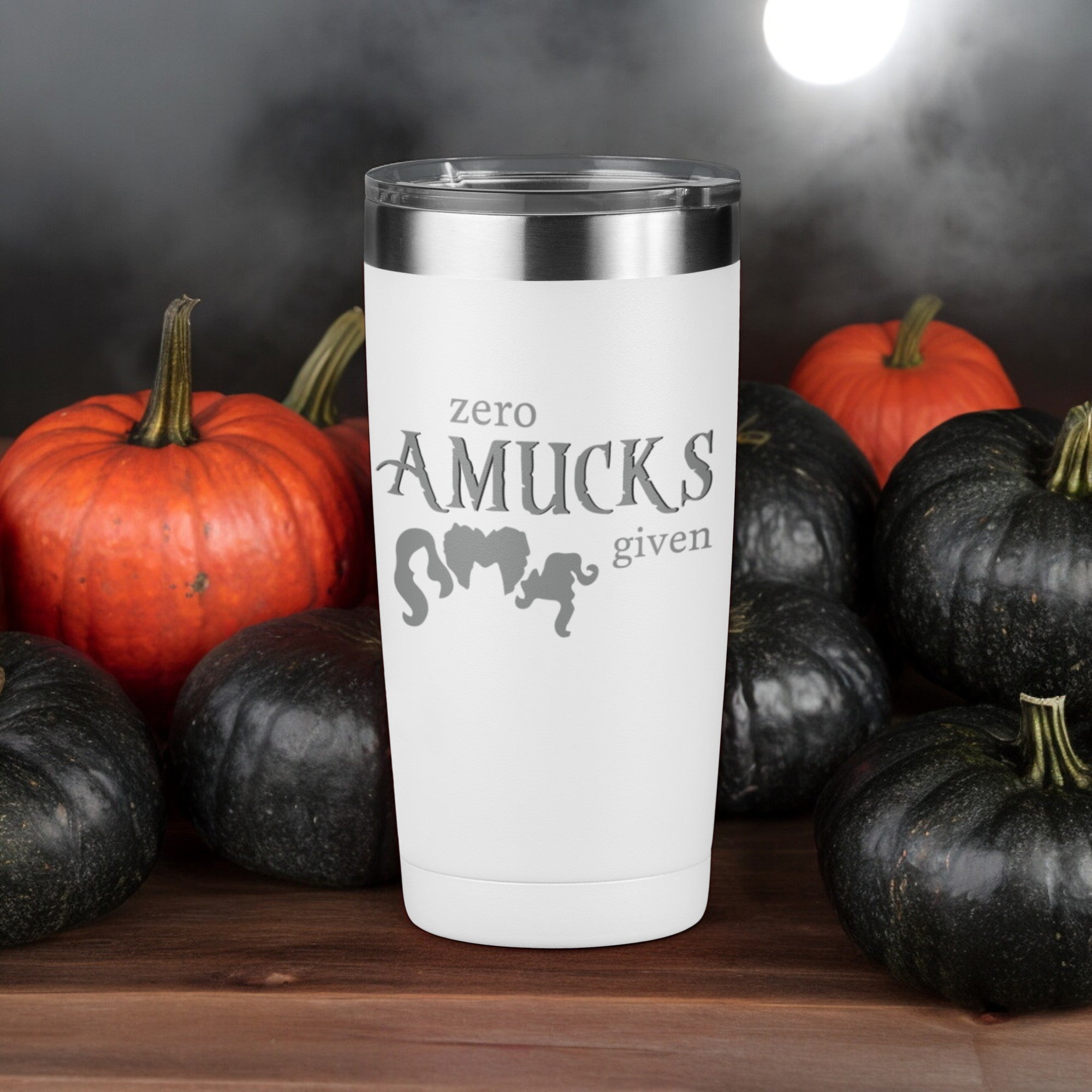 White tumbler with silver text that reads "Zero Amucks Given," featuring silhouettes of three witches' hairstyles, perfect for Halloween-themed drinkware.