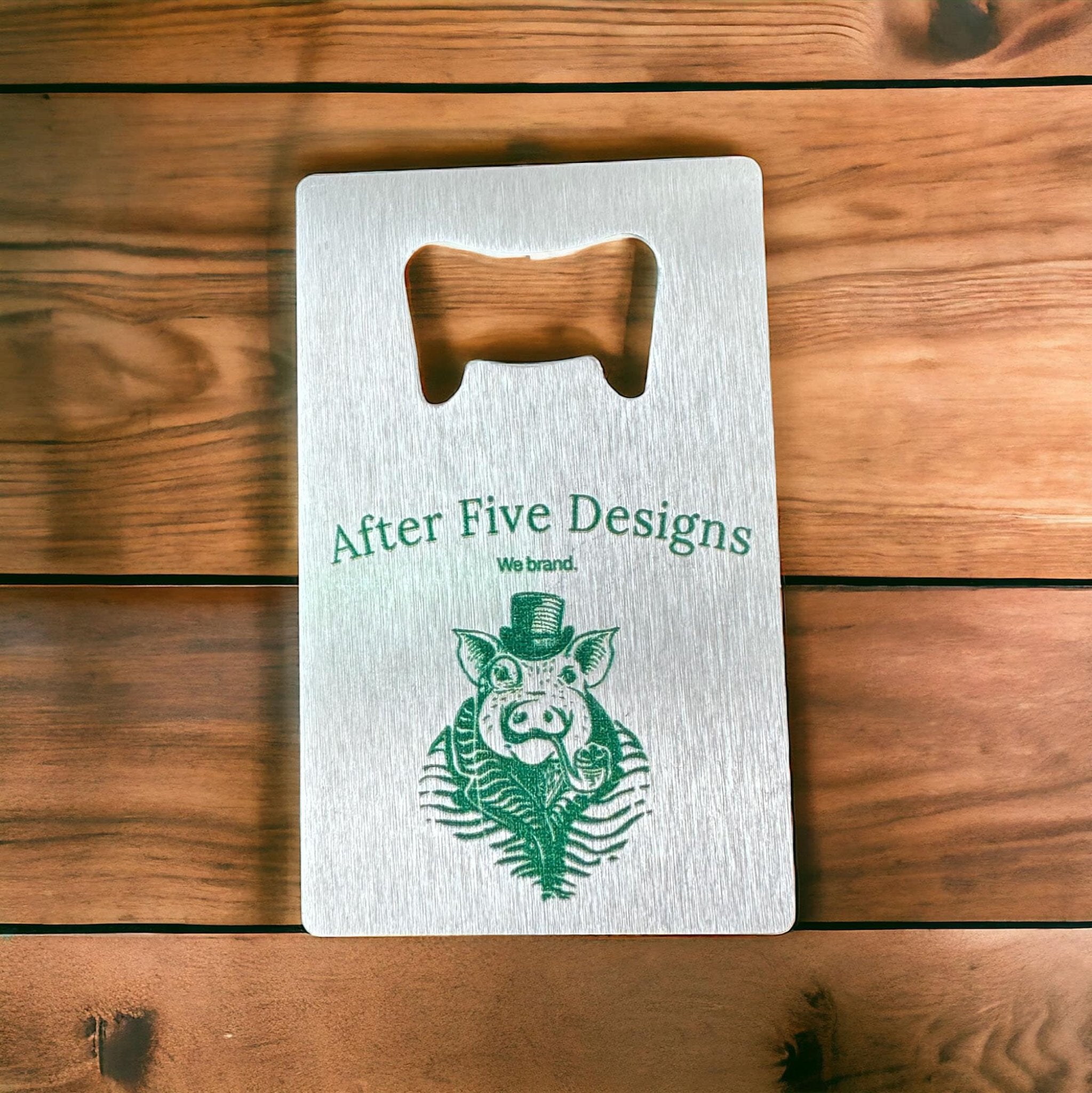 Custom metal bottle opener business card with "After Five Designs" logo featuring a pig in a top hat, ideal for unique branded promotional products or business gifts.